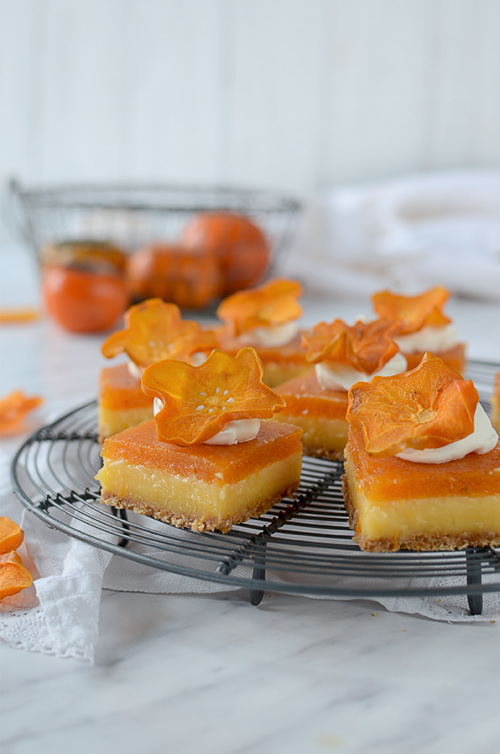 Best lemon bars ever, on grahan crust with creamy lemon curd layer and persimmon mousse. Decorated with whipped cream and dried persimmons